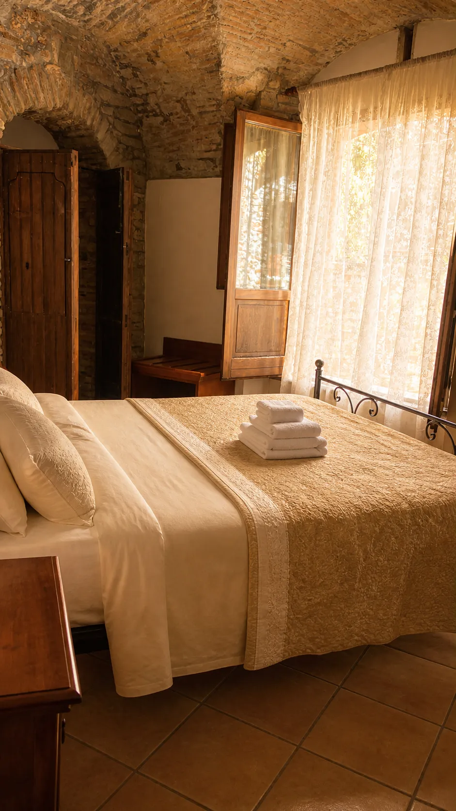 The double room beneath the stone vault, with lace curtains